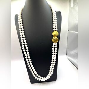 Les Bernard double-strand necklace white beads a gold-tone scallop shell clasp.